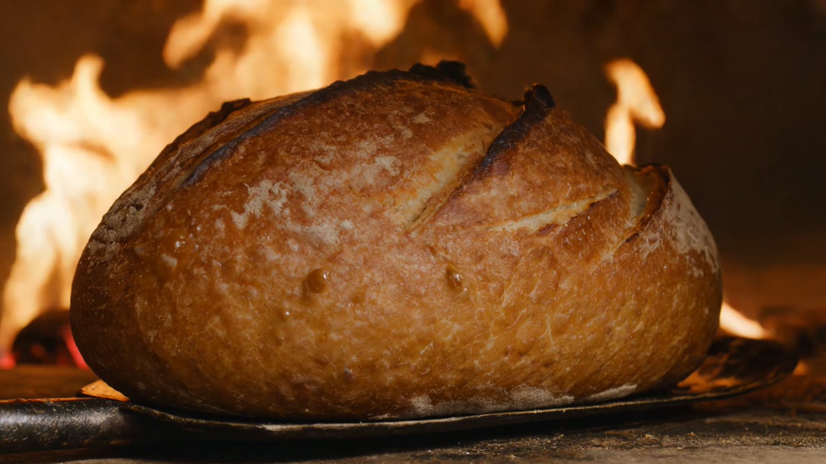 Goldbrauner Sauerteiglaib im lodernden Steinofen